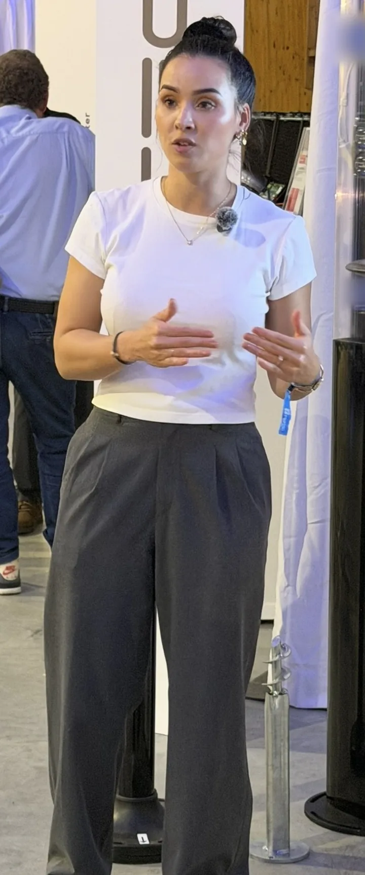 Eline in een beurshal, vertellend, handen erbij.