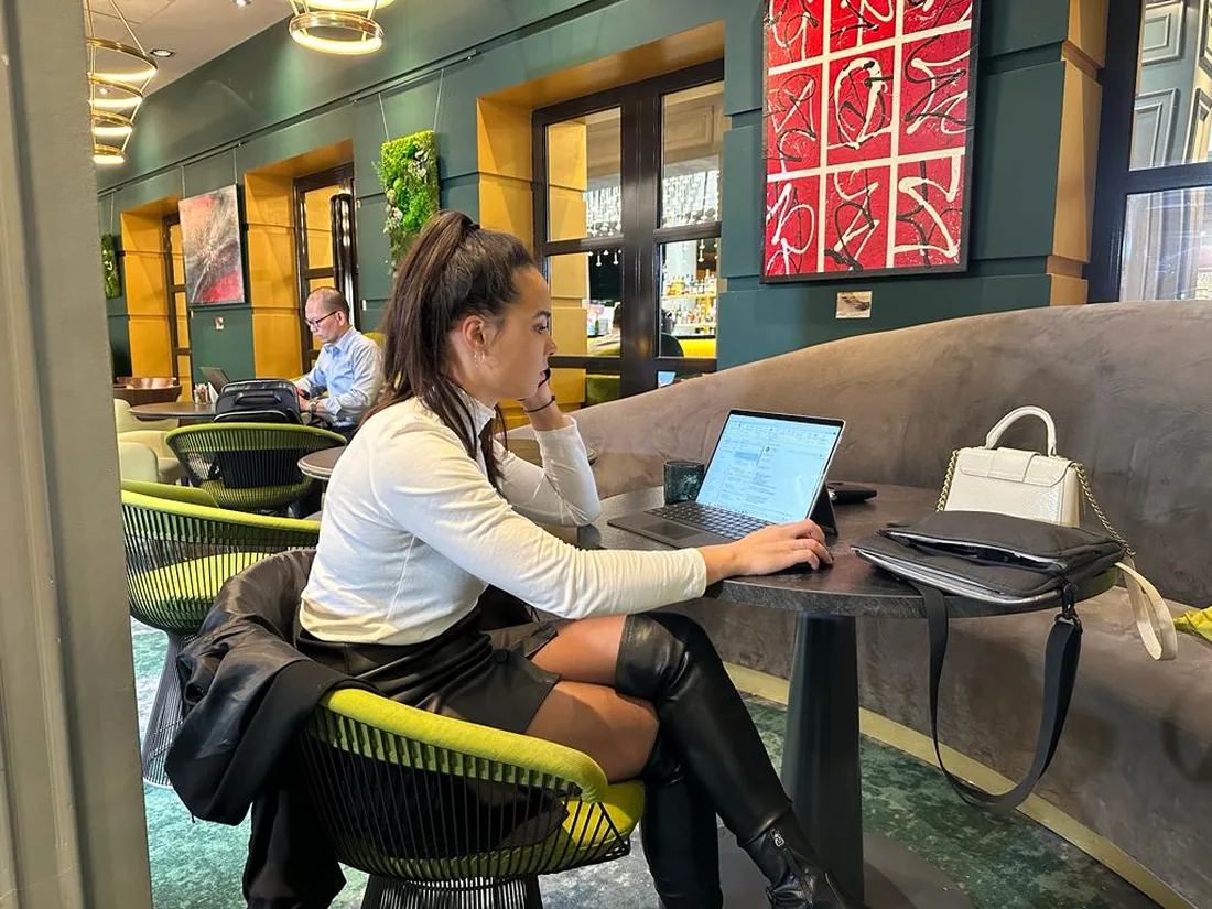 Eline werkt in een lounge met groene wanden en gele stoelen.