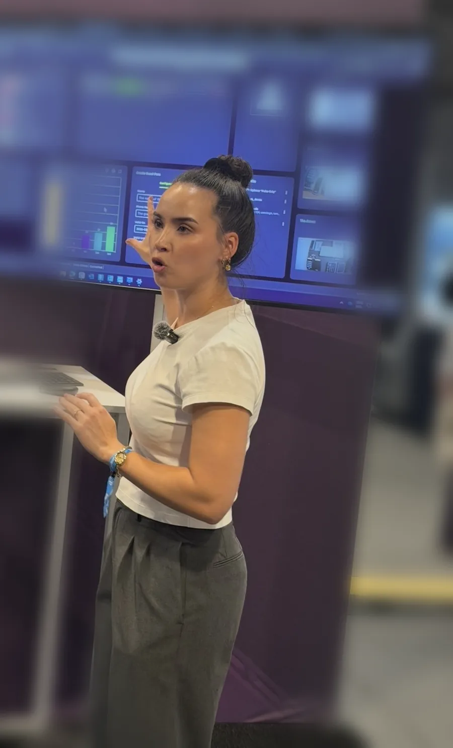 Eline presenteert voor een scherm, hand omhoog.