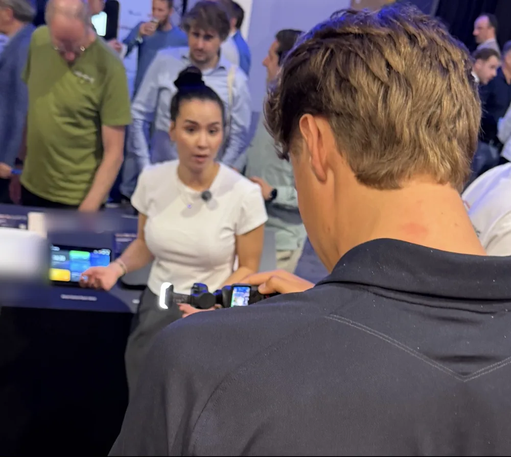 Eline vertelt op een beurs met publiek om haar heen.